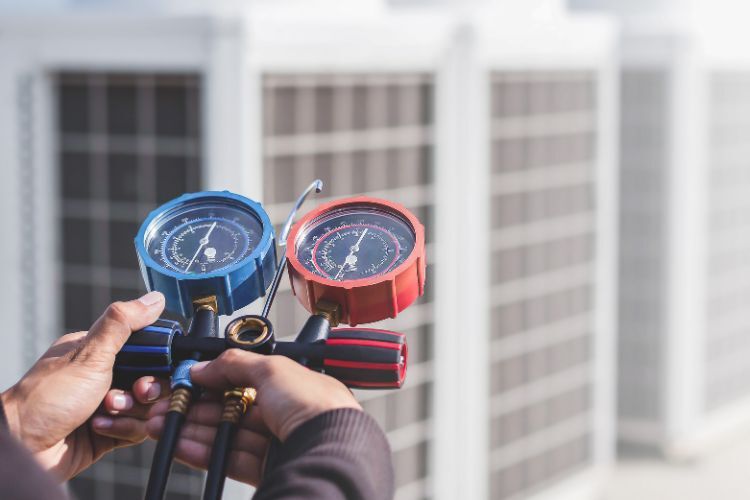 HVAC technician measuring commercial heat pump refrigerant levels to ensure optimal efficiency