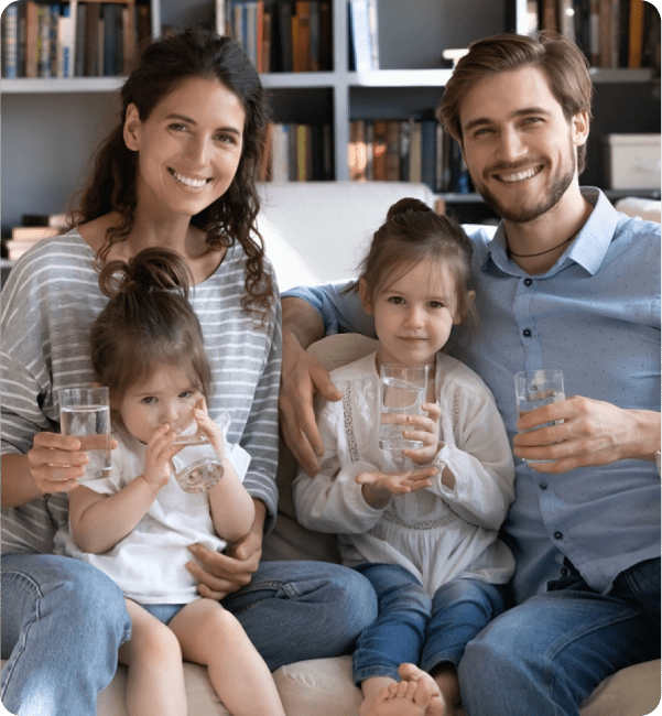 Happy family of four enjoying clean, filtered water from a commercial-grade purification system at home