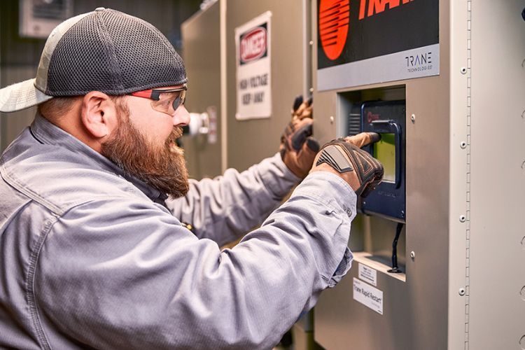 HVAC Engineer repairing a commercial furnace unit for better heating during winter